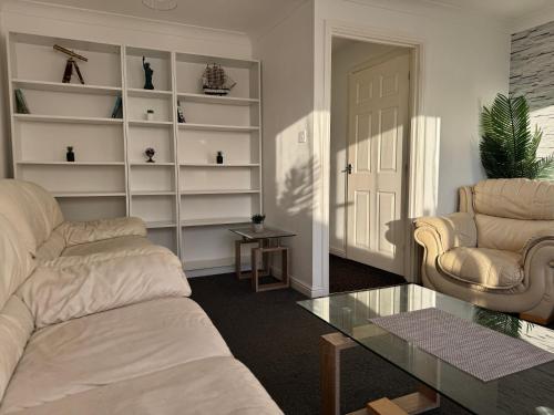 a living room with a couch and two chairs and a table at Stony Apartment House in Doncaster