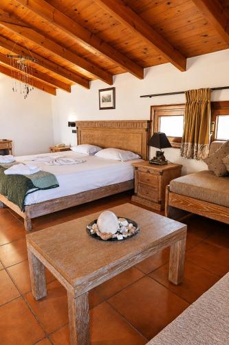 a bedroom with two beds and a table and a couch at Mylos Hotel Apartments in Platanias