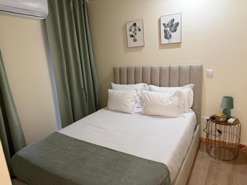 a bedroom with a bed with white sheets and pillows at Solar dos Caseiros in Macieiro da Maia