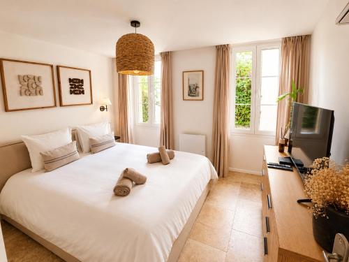 a bedroom with a white bed with two teddy bears on it at Charming house with rooftop - Gassin in Gassin