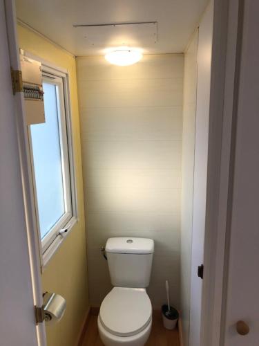 a small bathroom with a toilet and a window at Beach Break Bungalows Playa El Palmar in Cádiz