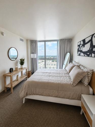 a bedroom with a large bed and a large window at Luxury Downtown Escape Pool, Spa and Cafe in Fort Myers