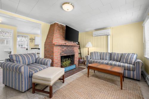 a living room with two couches and a fireplace at East Sandwich Beachfront Retreat in East Sandwich