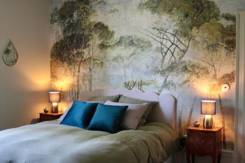 a bedroom with a bed with a painting on the wall at Demeure Les ragottières in Le Plessis