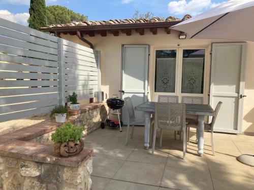 a patio with a table and chairs and a fence at Villa sport relax in Colle di Val d'Elsa