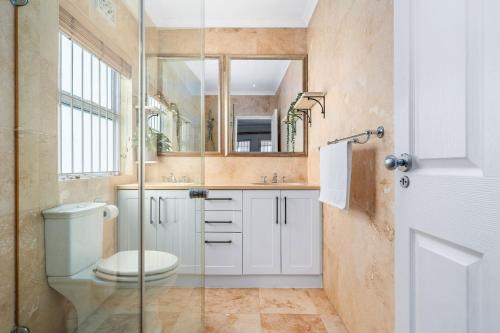 a bathroom with a toilet and a sink and a mirror at Sangrove Residence in Cape Town