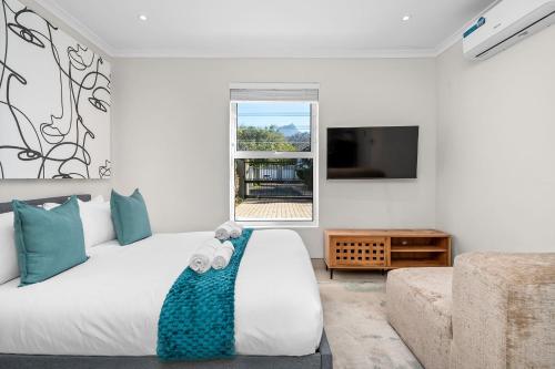 a bedroom with a bed with a teddy bear on it at Sangrove Residence in Cape Town