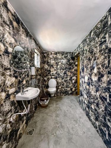 a bathroom with a sink and a toilet at Pearl Beach Resort in Covelong
