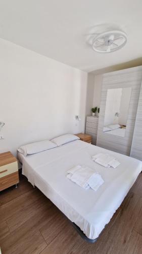 a bedroom with a large white bed and a mirror at Villa Epi in Sperlonga