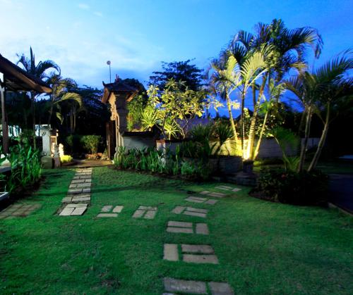 a backyard with a grass yard with a pathway at Alamanda Bingin in Uluwatu