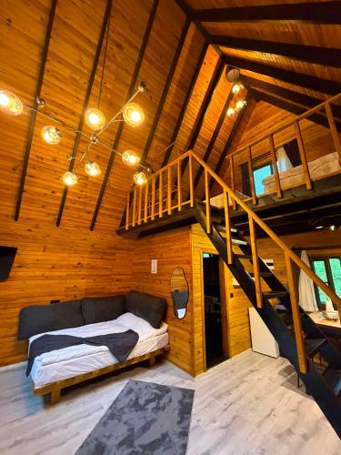 a bedroom with a bed and a staircase in a room at Yonga Bungalov in Akcaabat