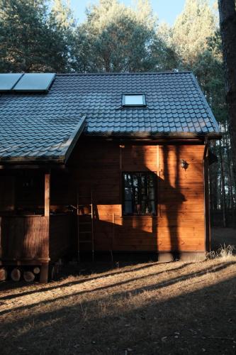 eine kleine Holzhütte mit Schindeldach in der Unterkunft Marusia in Wajków