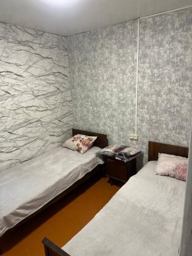 two beds in a room with a stone wall at Tsovazard Life Lake in Tsovazard