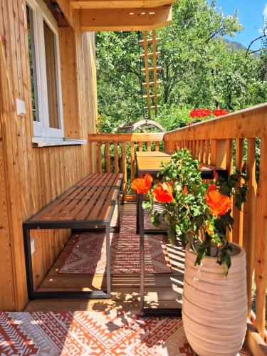 a wooden porch with a bench and flowers in a vase at Schafberg Luxury Apartment in St. Wolfgang