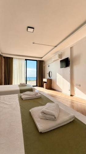 a hotel room with two beds with towels on the floor at Pavlonya Garden in İntepe