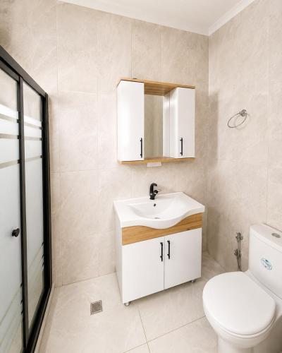 a bathroom with a white sink and a toilet at Pavlonya Garden in İntepe