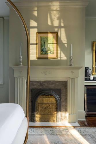 a bedroom with a fireplace with a picture on the wall at The Nicholas Veranda King Suite - Steps to King in Charleston