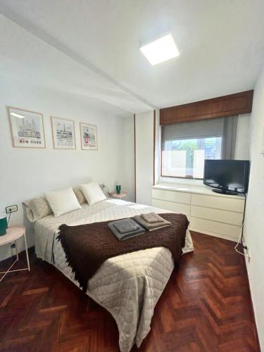 a bedroom with a bed and a flat screen tv at Apartamento en A Coruña in A Coruña