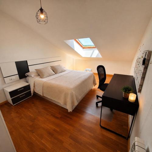 a bedroom with a bed and a desk and a skylight at El Burgo Eclipse Retreat in El Burgo de Osma