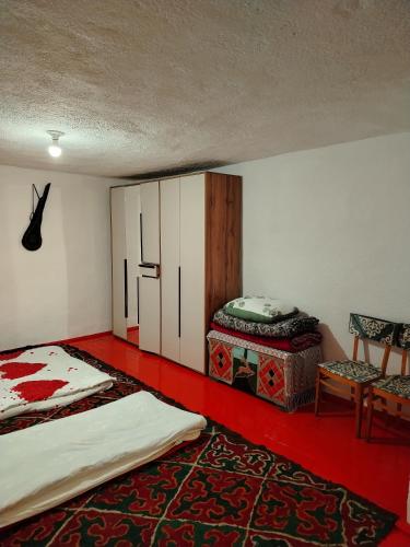 a room with two beds and a cabinet and a chair at Chyrak home in Ak-Osten