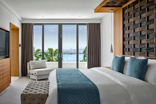 a bedroom with a large bed and a large window at Parklane, a Luxury Collection Resort & Spa, Limassol in Limassol