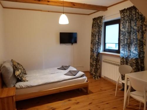 a small room with a bed and a window at Termalne Pokoje in Uniejow