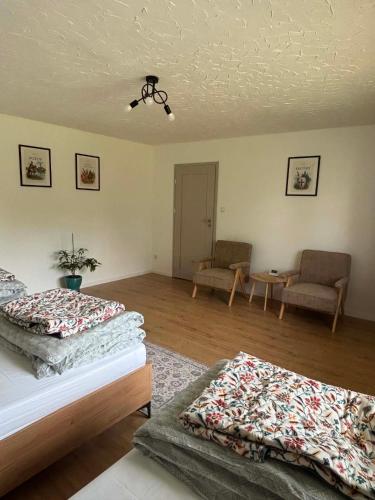 a bedroom with two beds and a table and chairs at Domek Wśród Pisarzy in Strawczynek