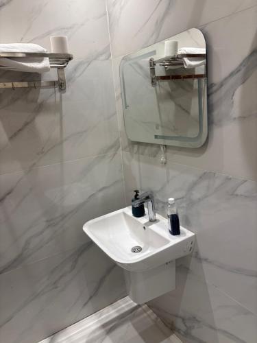a white bathroom with a sink and a mirror at Dera October city in 6th Of October