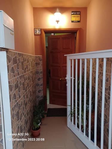 a hallway with a staircase and a brown door at Habitaciones Gioly in Puerto del Rosario