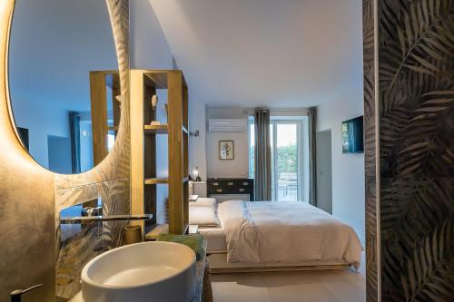 a bathroom with a bed and a sink and a mirror at Un Occhio Sul Lago in Dormelletto