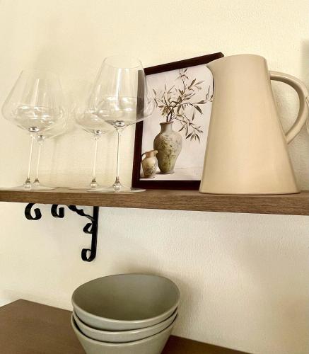 a shelf with wine glasses and a toilet and a lamp at La Morra Relax in La Morra