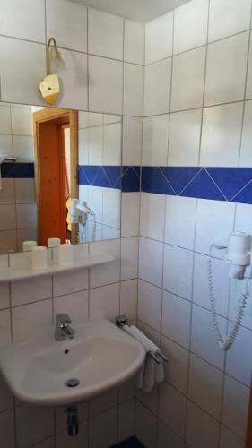 a white bathroom with a sink and a mirror at Alpenhotel Gurgltalblick in Nassereith
