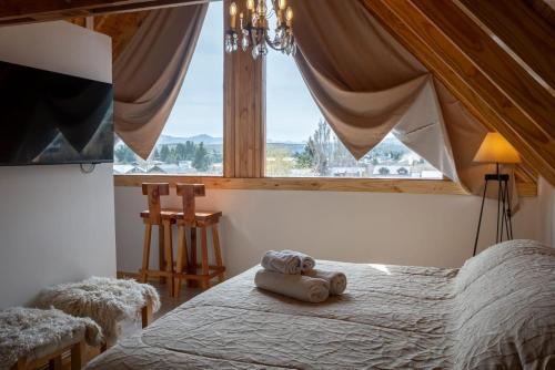 a bedroom with a bed with a large window at Complejo Casa Roja in Dina Huapi