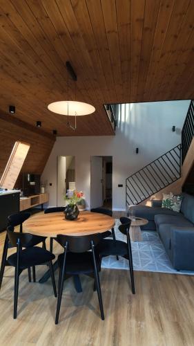 a dining room and living room with a wooden ceiling at ArcChalet Transylvania in Borzont