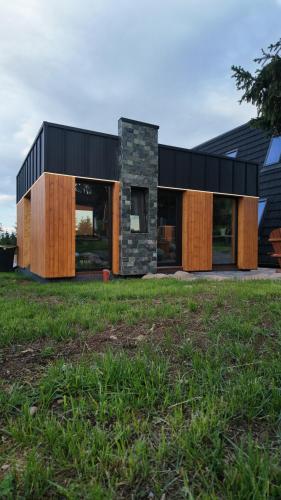 a modern house with a black roof and wood at ArcChalet Transylvania in Borzont