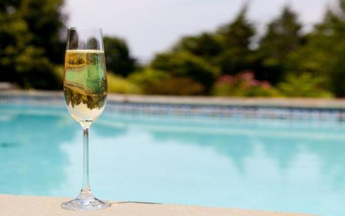 a glass of wine sitting next to a swimming pool at Agriturismo Il Boschetto in Ornago