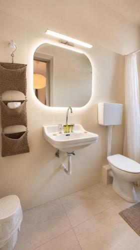 a bathroom with a sink and a toilet and a mirror at Villa Irene in Poros
