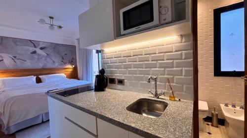 a hotel room with a sink and a bed at Le Flâneur Boutique Hotel in Pergamino