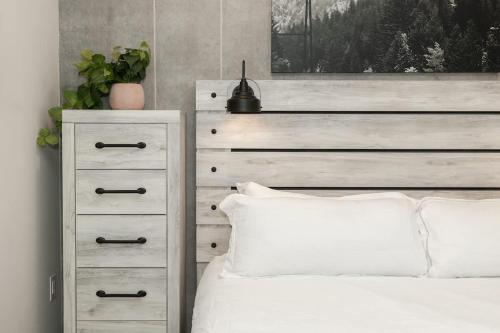 a bedroom with a white bed with a dresser and a bed sidx sidx sidx at NEW Ski-In Ski-Out Romantic Studio for Two in Winter Park