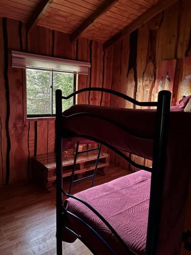 a bedroom with a bunk bed in a cabin at Cabaña Refugio Rustica in Pucón