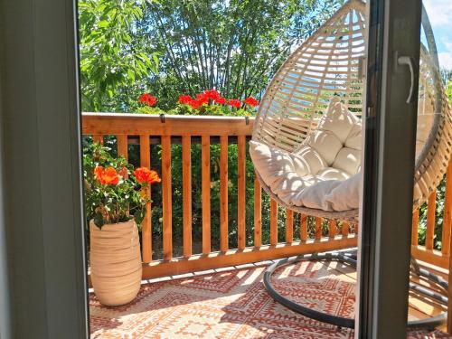 a porch with a swing and a vase with flowers at Schafberg Luxury Apartment in St. Wolfgang