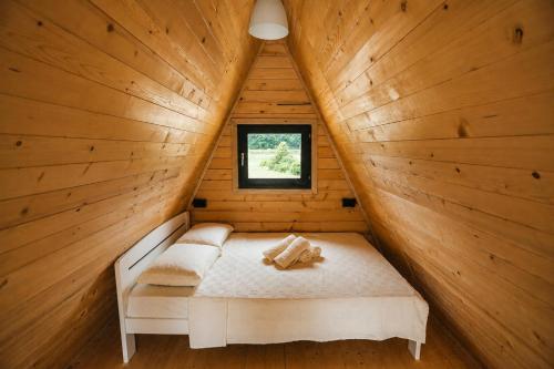 a bed in a wooden cabin with a window at Rzav A - Frames in Arilje