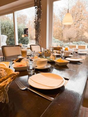 a long table with plates and utensils on it at Wolfcenter Gästezimmer in Dörverden