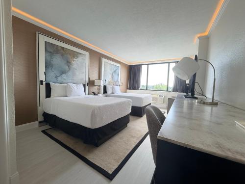 a hotel room with two beds and a desk at Inn at Lebanon - Hershey & Manheim area in Lebanon