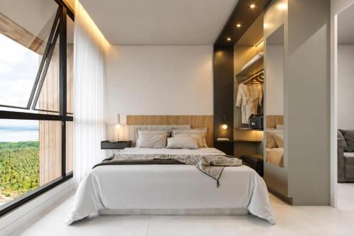 a bedroom with a large bed and a large window at Apartamento Beach Resort in Salinópolis