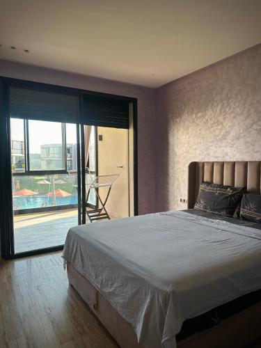 a bedroom with a large bed and a large window at Relaxing residence oceanic Sidi rhal in Sidi Rahal