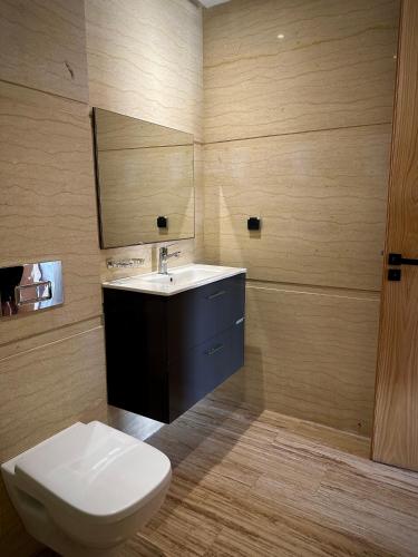 a bathroom with a toilet and a sink and a mirror at Relaxing residence oceanic Sidi rhal in Sidi Rahal