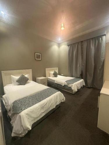 a hotel room with two beds and a window at شقق نزل النخيل in Riyadh
