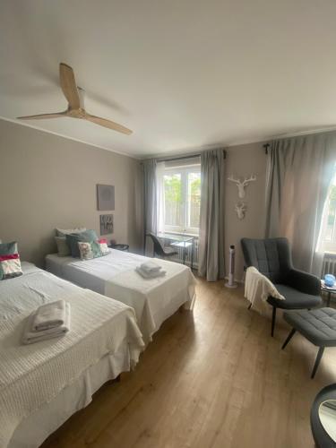 a bedroom with two beds and a chair and a window at Casa Soden, Artful living close to Frankfurt in Bad Soden am Taunus