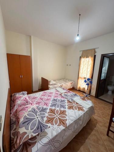 a bedroom with a large bed with a colorful comforter at General's Beach House in Kavajë